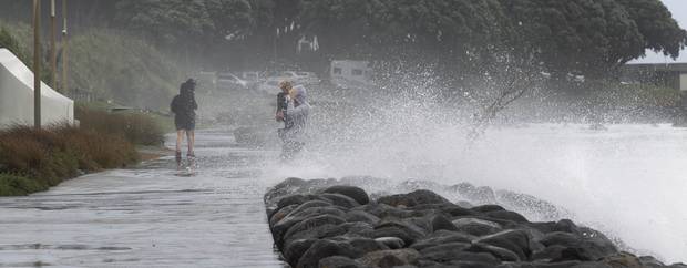 People duck for cover as waves lash the New Plymouth Walkway in central New Plymouth this afternoon as cyclone Gita sweeps down the west coast towards the South Island. Photo Alan Gibson
