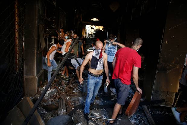 Protesters walk in an damaged building during clashes with police. Photo / AP