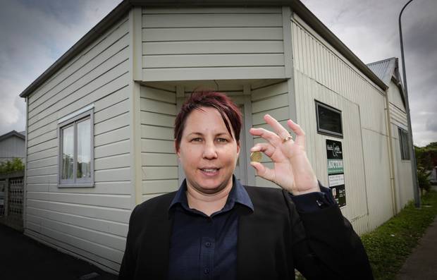 Sales consultant Katrina Wyatt of Black & White Real Estate has put a $1 reserve on the four-bedroom Napier South house pictured behind her. Photo / Warren Buckland