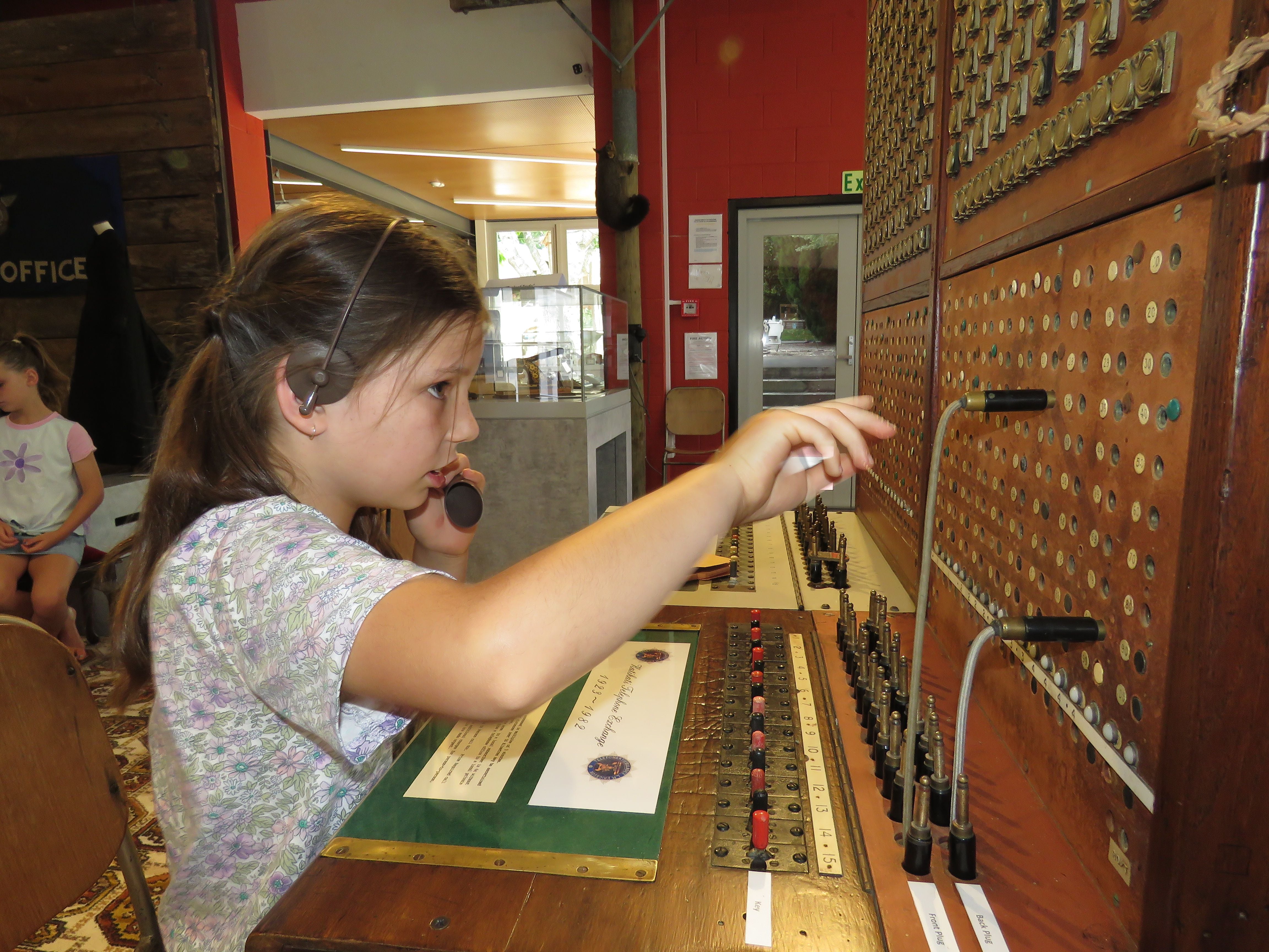 Isla Cave has a turn at being the operator of the old Katikati Telephone Exchange. Photo: Merle Cave