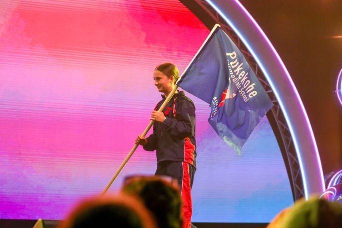 A flag bearer from Pukekohe Intermediate School on stage during the Opening Ceremony of the 2024 Zespri AIMS Games on Sunday September 8, 2024. 