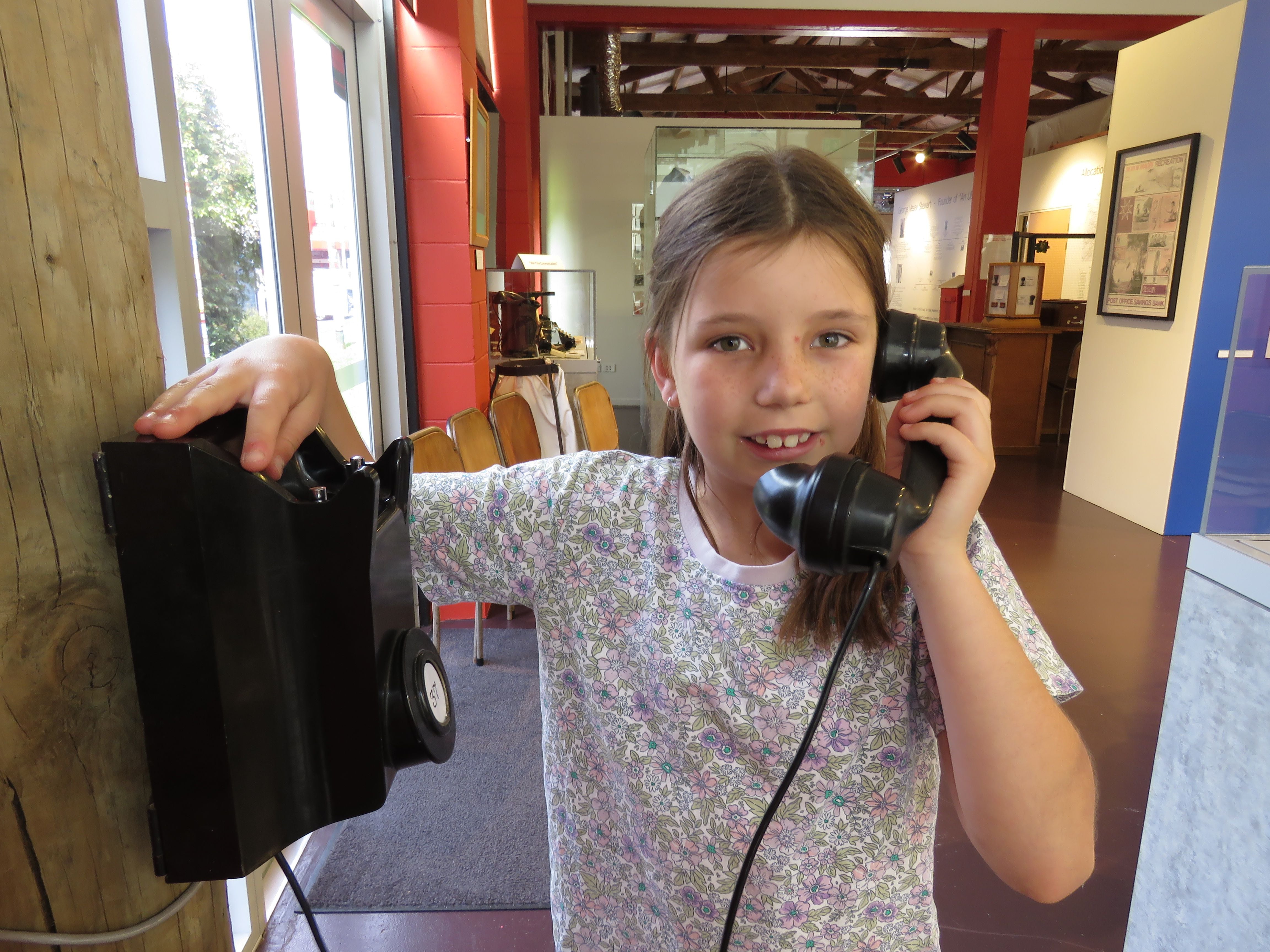 Isla Cave receives a phone call from her sister via the old Katikati Telephone Exchange. Photo: Merle Cave