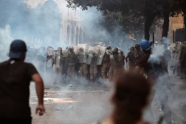 Lebanese soldiers stand among tear gas during clashes with protesters as part of a protest against the political elites and the government after this week's deadly explosion at Beirut port. Photo / AP