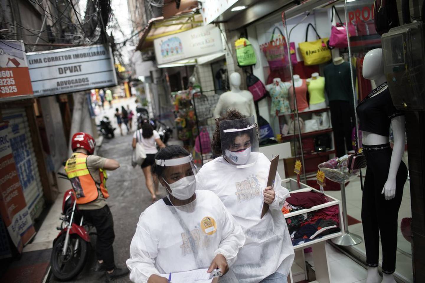 Health workers walk through the Rocinha slum in Rio de Janeiro, Brazil, to test people for Covid-19 as part of a rapid test campaign. Photo / AP