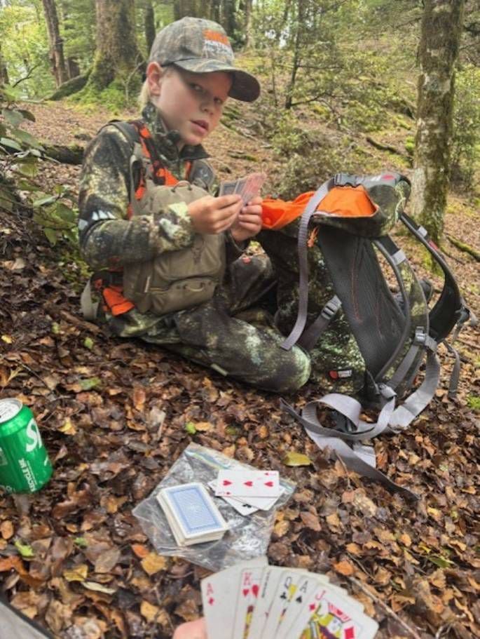 Fletcher Fairbairn playing cards with Jamie while taking a break from hunting.