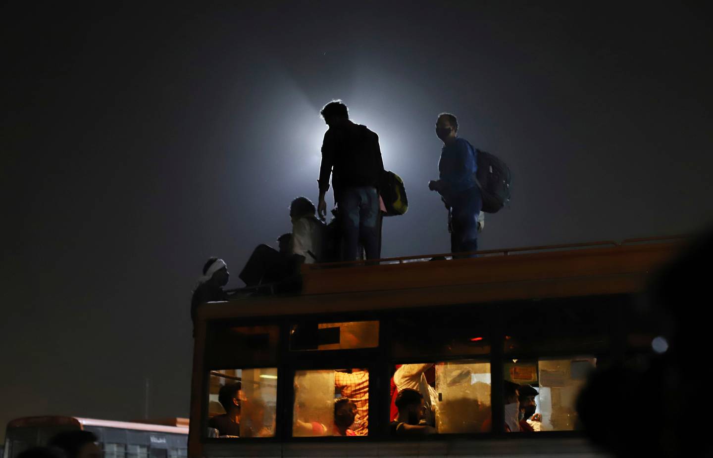 Migrant workers leave for their villages from a bus terminal, in New Delhi, India. Photo / AP