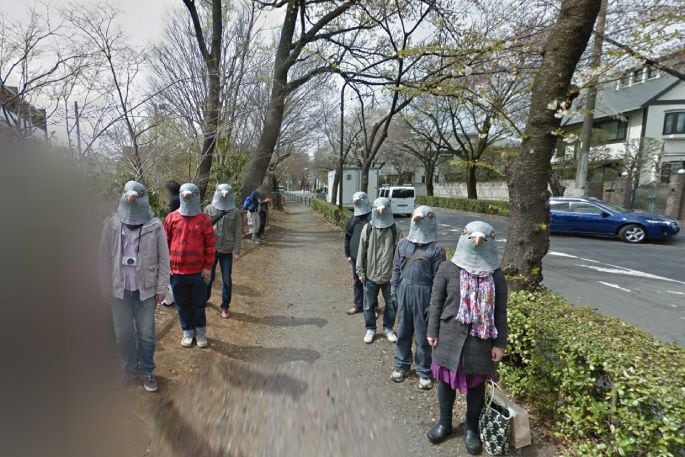 A flock of pigeon-masked people on a sidewalk in Tokyo. Photo/Google Street View.