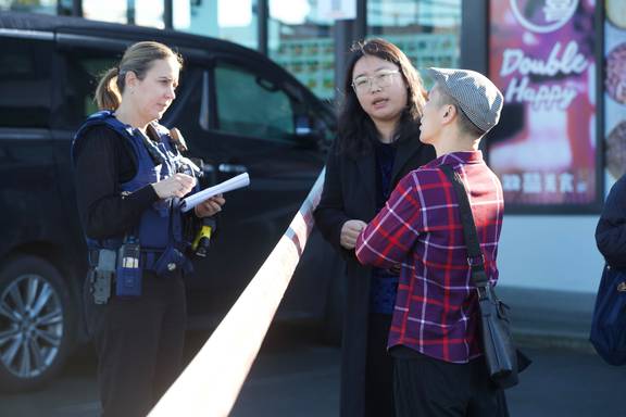 Restaurant owner Guang Qing Ying (right) talks to police with the aid of MP Naisi Chen acting as an interpreter. Photo / Jason Oxenham