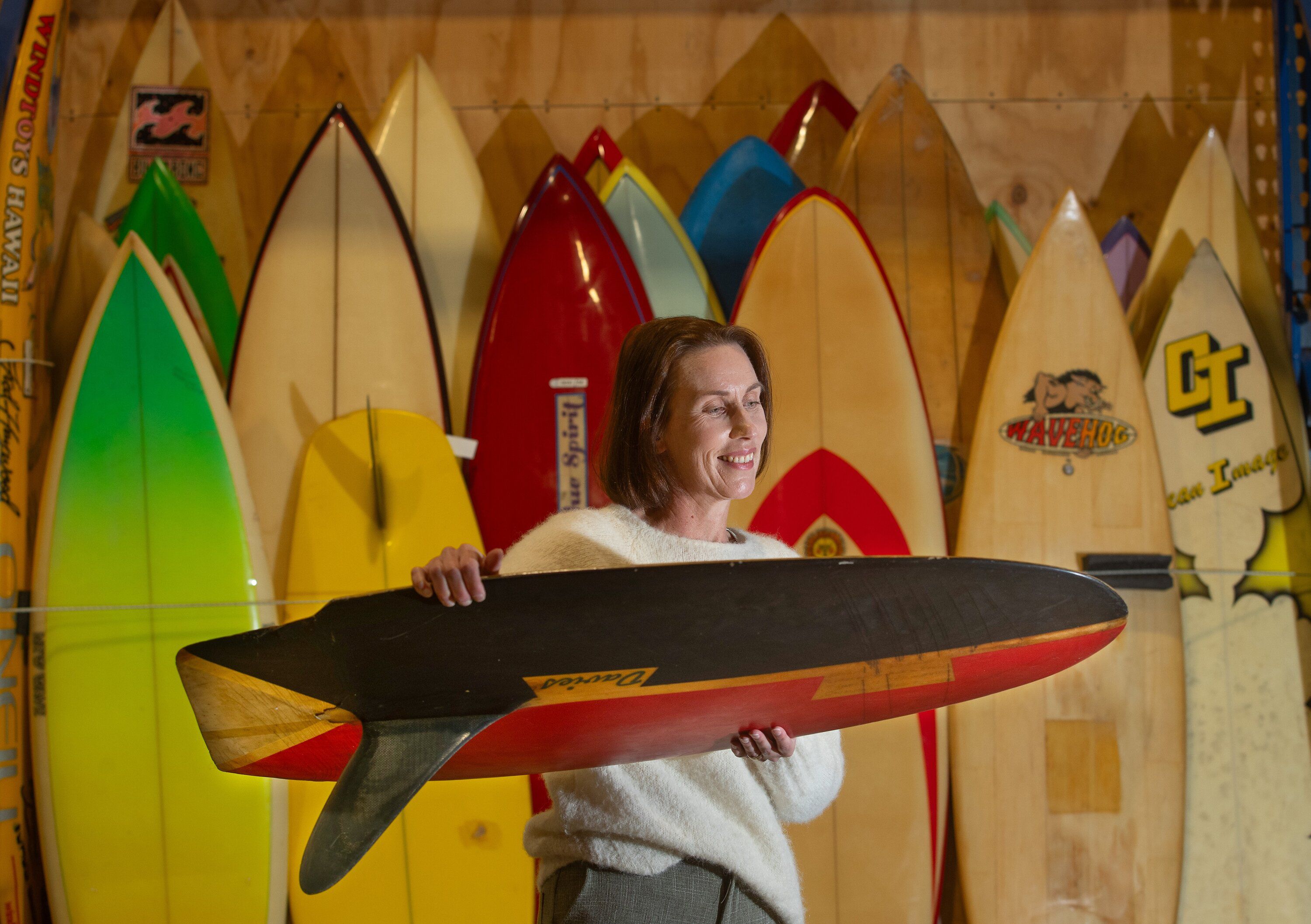 Tauranga museum curator Fiona Kean with Dusty Waddell’s collection of 130 Kiwi surfboards. Photo / John Borren