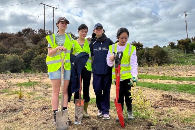 Students Sylvie Brown, Alisa Shang, Clara Rocha and Emilia Yip helping to plant 4500 plants in Kōpūrererua Valley on September 29. Photo: Supplied.