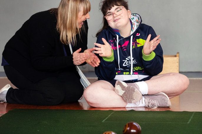 Tauranga Special School teacher Sara Thorburn shares a joyous moment with student Laura Hollands during a practice for the indoor bowls competition. Photo: Alan Gibson.