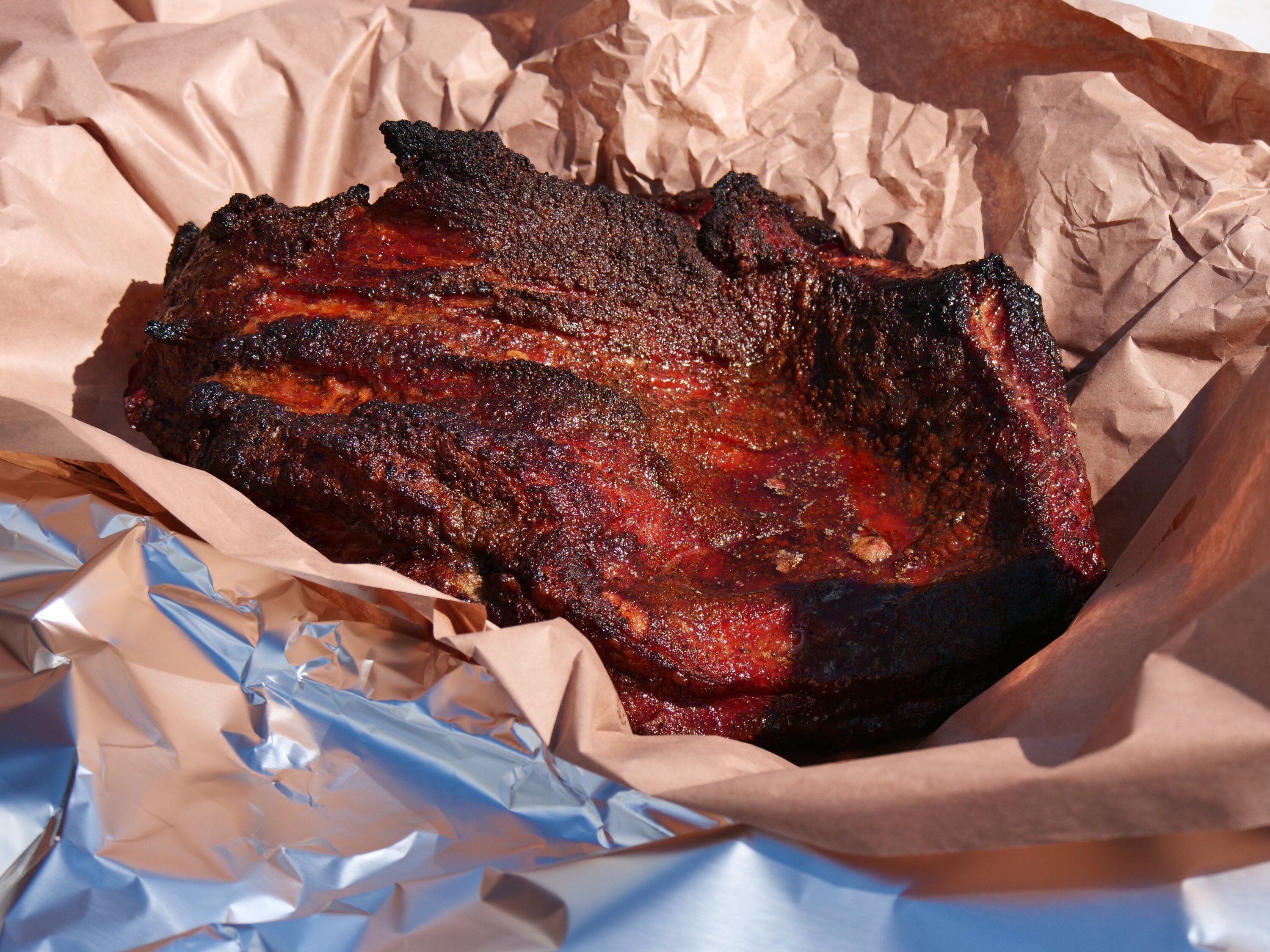 The Brisket, about to be wrapped in peach butcher paper and put back into the smoker. Photo / Tom Eley