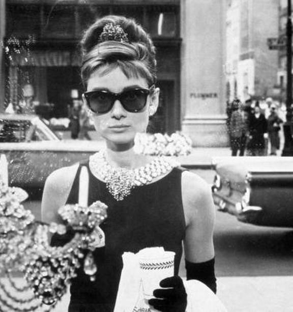 British actress Audrey Hepburn choosing a bag helped by the