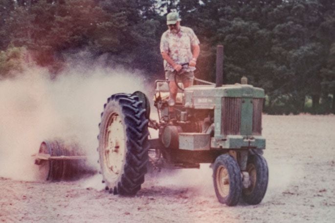 Reece’s father Neil Houghton working with the John Deere 70 in the 1990s prior to restoration. Photo: Catherine Fry