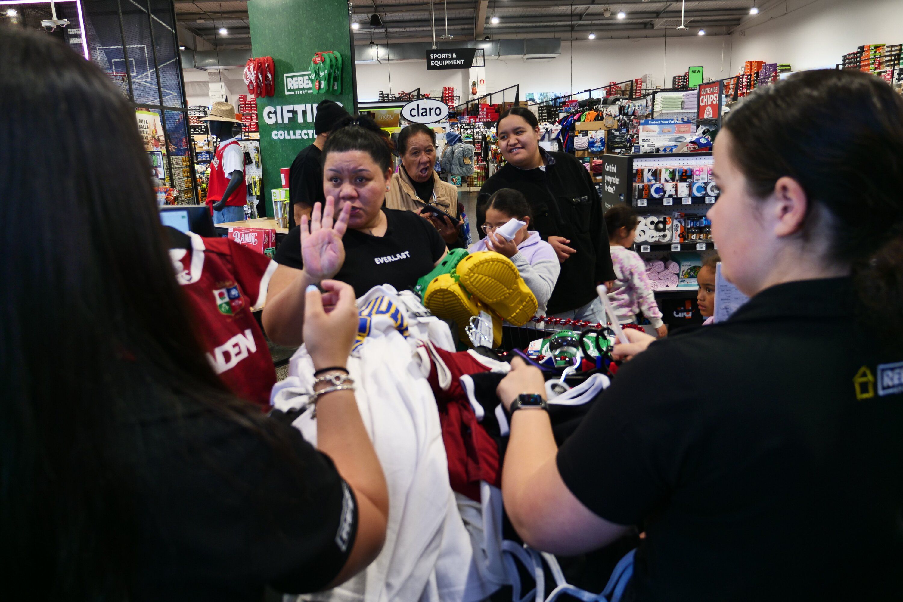 The staff at Rebel Sport Tauranga scan the items in Howden-Turnbull's trolley.