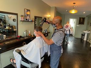 Albion barber cuts hair, supports children in community