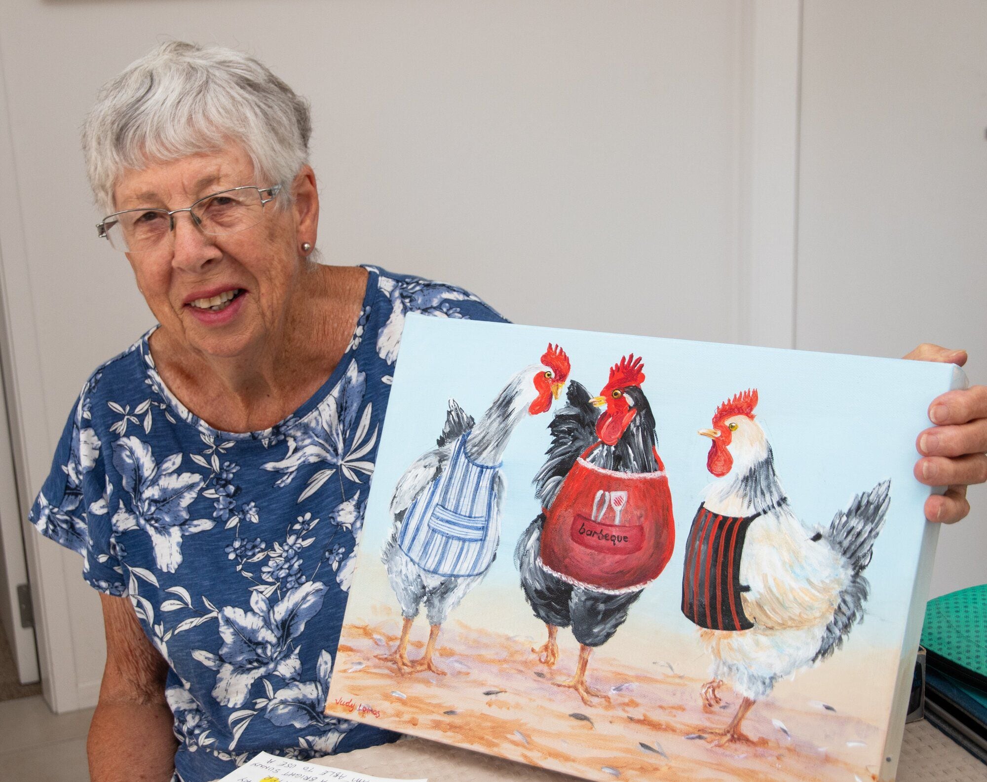  Judy Lomas with her painting Barbeque Chickens. Photo / Bob Tulloch